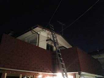 屋根修理のためハシゴを架ける