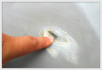 陸屋根の防水層の一部分が凹んで傷ついています